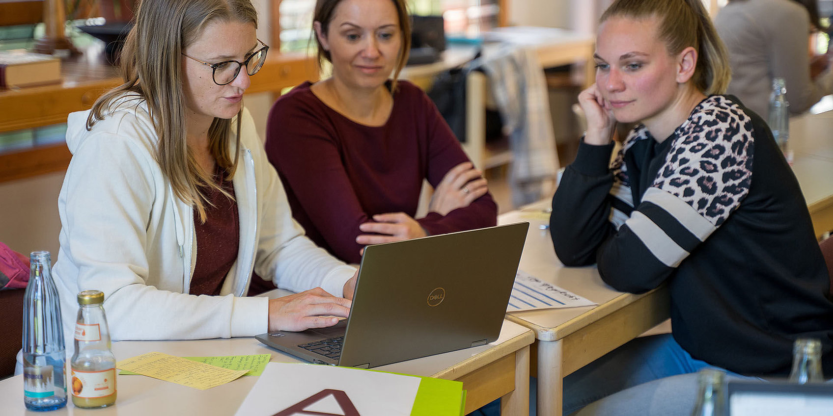 Teilnehmende der DiaCampus Akademie arbeiten am Laptop zusammen
